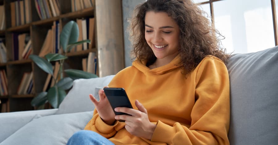 Frau auf Sofa mit Handy